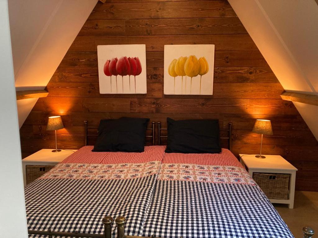 a bedroom with paintings of fruit on the wall at Tiny House Tulp in Oudesluis