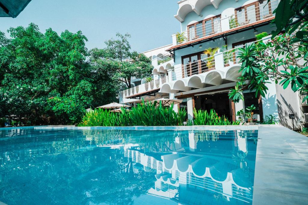 a swimming pool in front of a building at iRoHa Garden Hotel & Resort in Phnom Penh