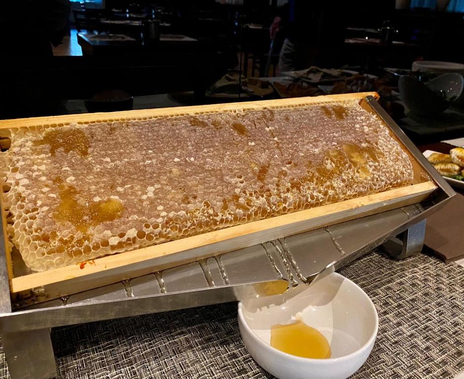 a container filled with honey next to a bowl of honey at Hotel Principe di Piemonte in Rimini