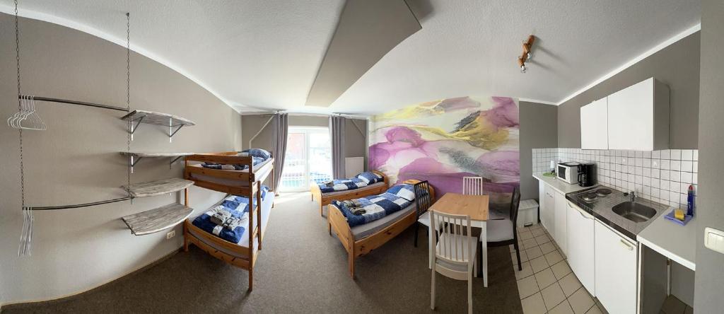 Zimmer mit 2 Etagenbetten und einer Küche in der Unterkunft Hostel Fehmarn Ferienwohnung in Fehmarn