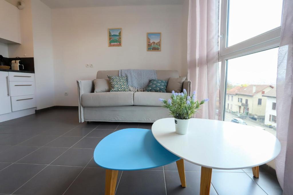 un salon avec une table blanche et un canapé dans l'établissement Cocon Annécien entre lac et montagne classé 1 étoile, à Annecy