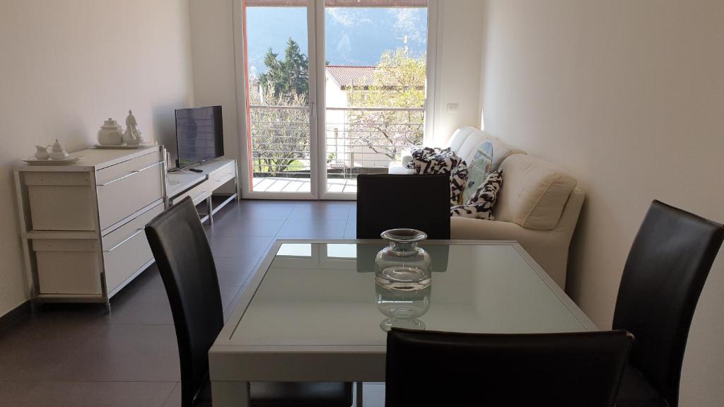 sala de estar con mesa, sillas y sofá en modern appartament en Porlezza