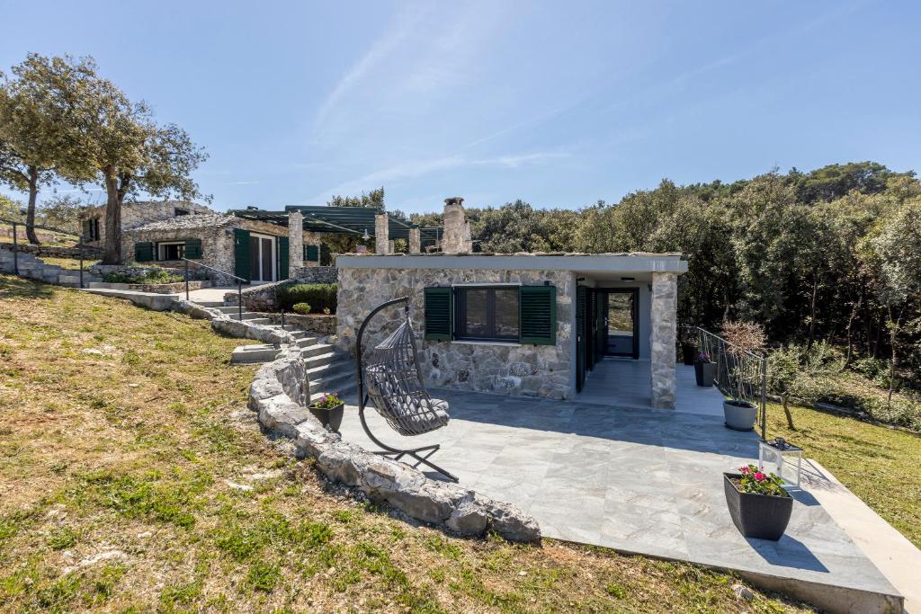 a stone house with a bench in a yard at Vila Scripea in Škrip