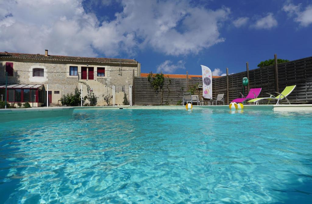 a large swimming pool with chairs in a building at Les Chambres de Montplaisir in Marsillargues