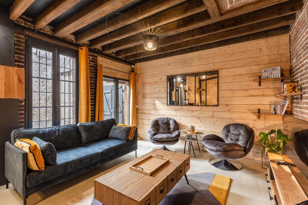 uma sala de estar com um sofá e duas cadeiras em L'Atelier d'Eléa - 4 - Terrace - Indus-chic in the heart of Honfleur - 6 P em Honfleur