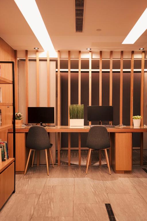 an office cubicle with two desks and two chairs at Hub Hotel Kaohsiung Yawan Branch in Kaohsiung