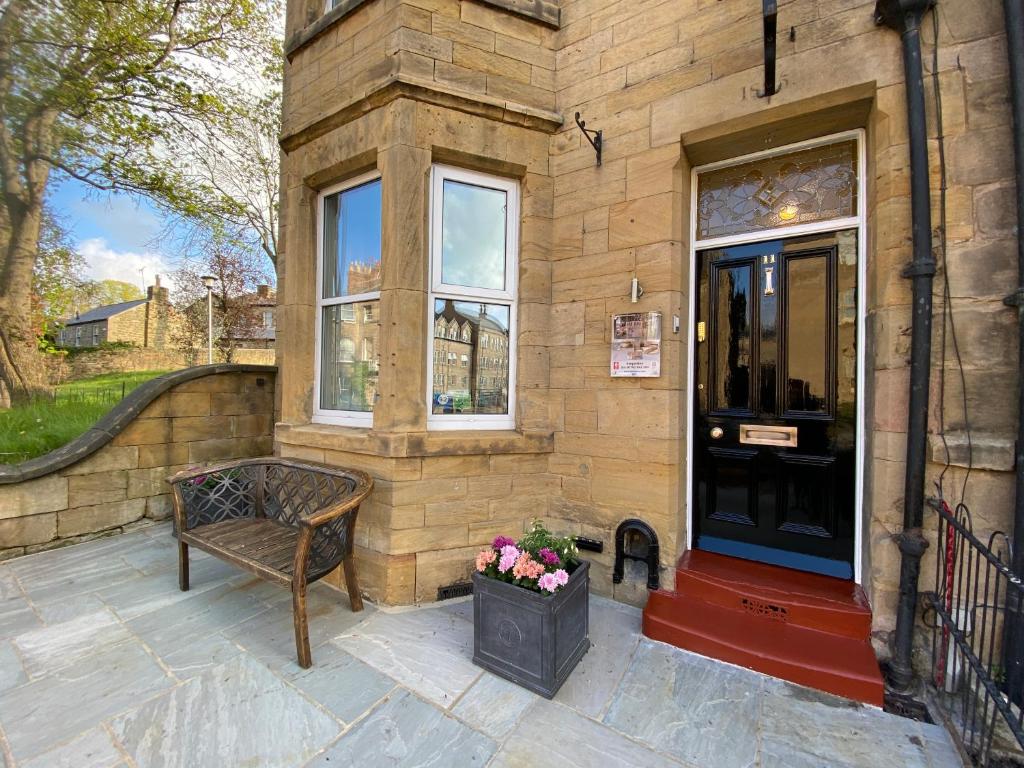 un banco sentado fuera de un edificio con ventana en Tate House, en Alnwick