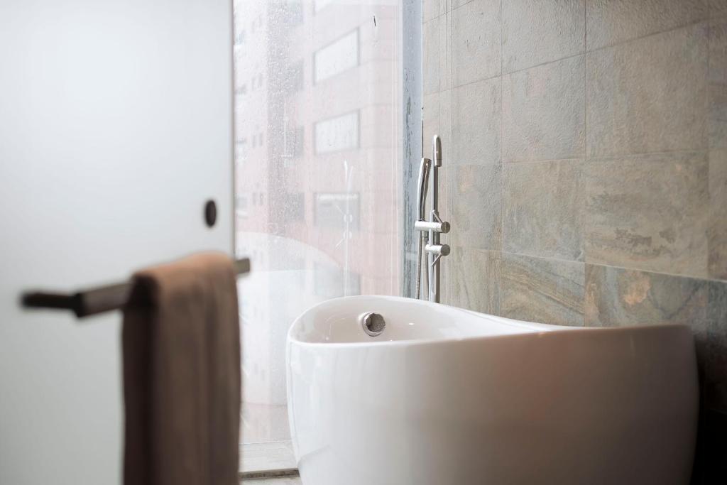 a white sink in a bathroom with a window at Hub Hotel Kaohsiung Yawan Branch in Kaohsiung
