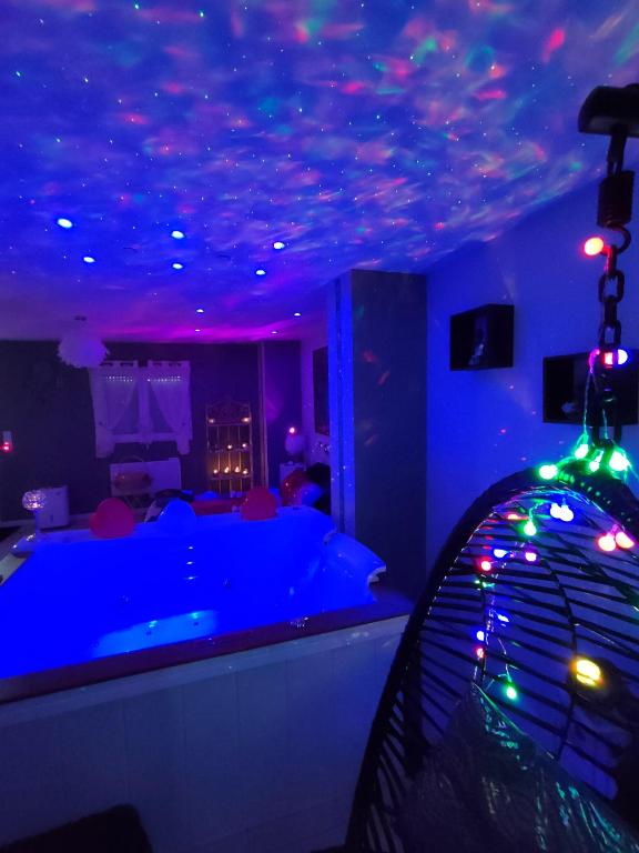 un salon avec des lumières bleues au plafond dans l'établissement Loft avec Baignoire SPA LÉcrin Romantique, à Ochancourt