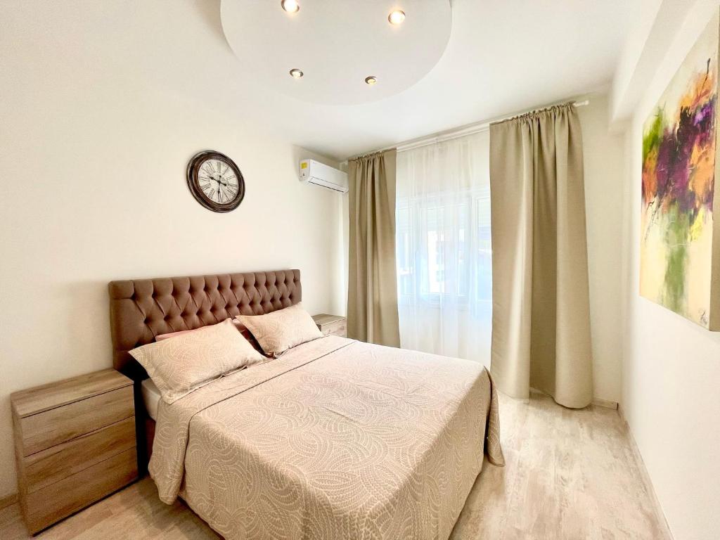 a bedroom with a bed and a clock on the wall at 100 m to the beach Sea La Vie 3 bedroom Apartment in Limassol