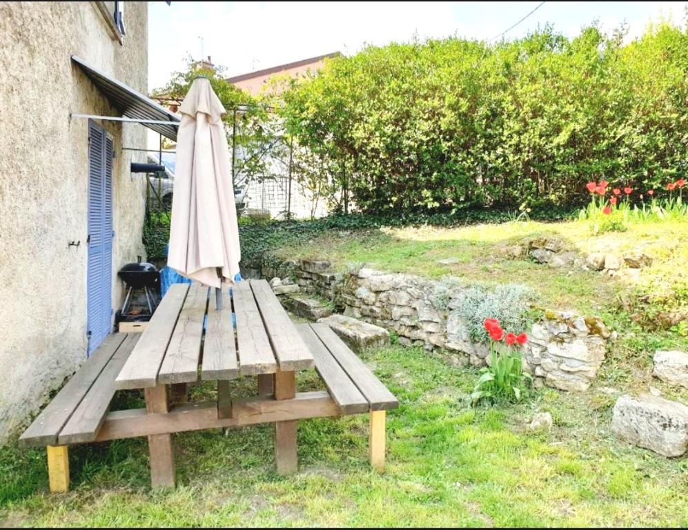 eine Holzbank mit einem Regenschirm und einem Tisch in der Unterkunft Gite de Circourt in Buxières-sous-les-Côtes