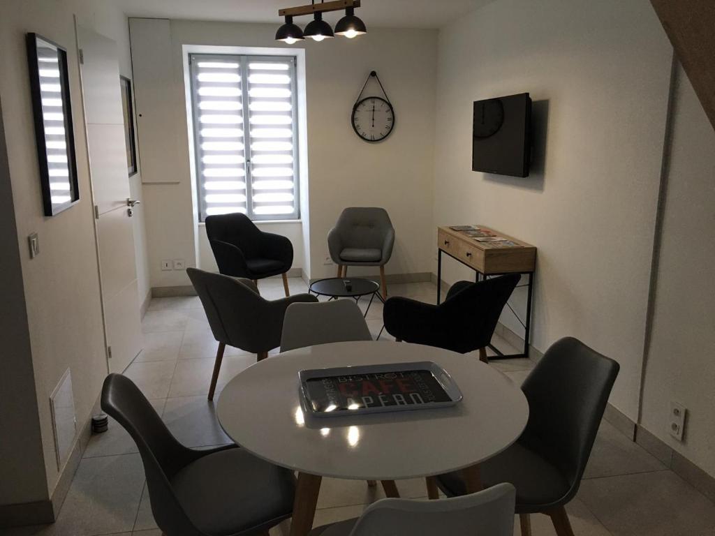 a room with a table and chairs and a tv at Gîte La Fontaine in Mer