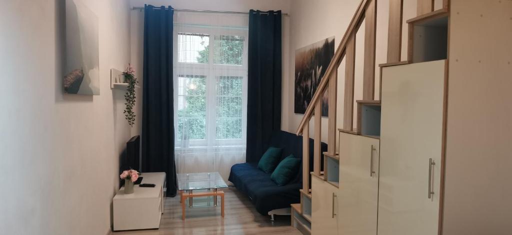 uma sala de estar com um sofá azul em frente a uma janela em New cosy studio em Karlovy Vary