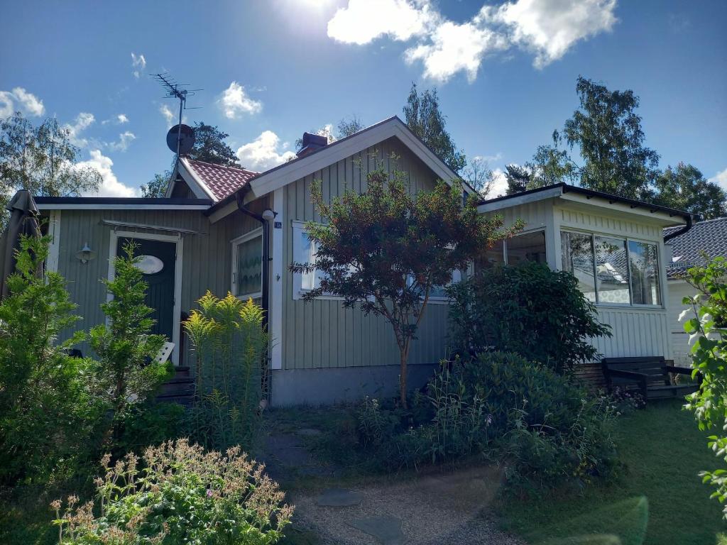 a small house with a garden in front of it at Mysig stuga i naturskönt område. in Vetlanda