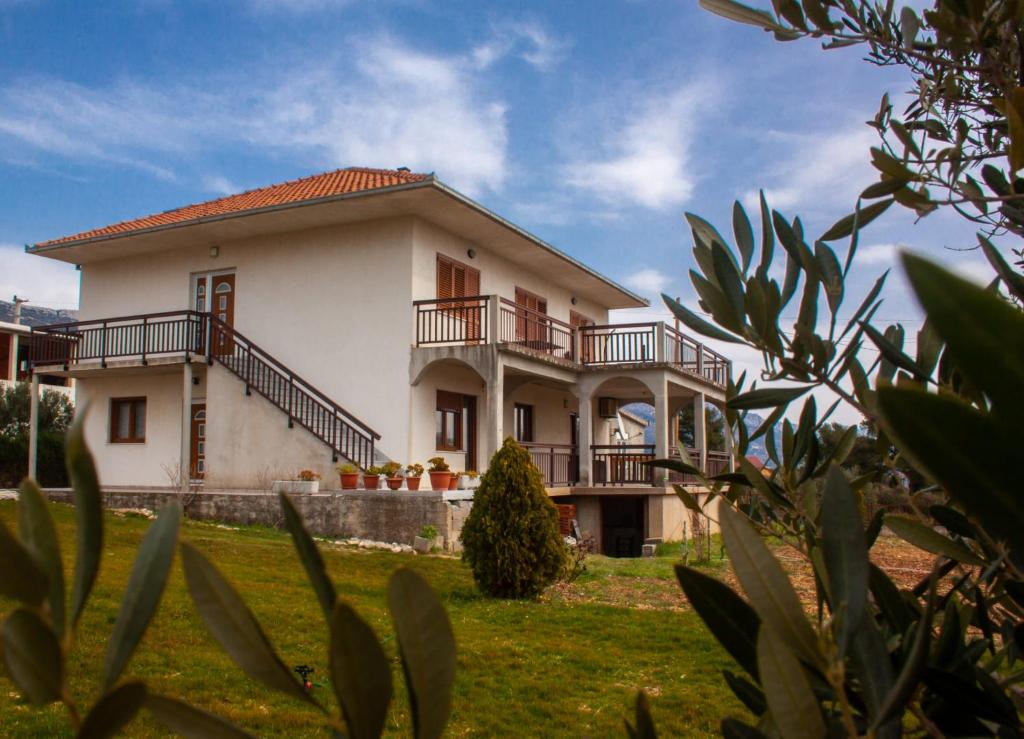 een groot wit huis met balkons bij Apartment Juric in Kaštel Novi