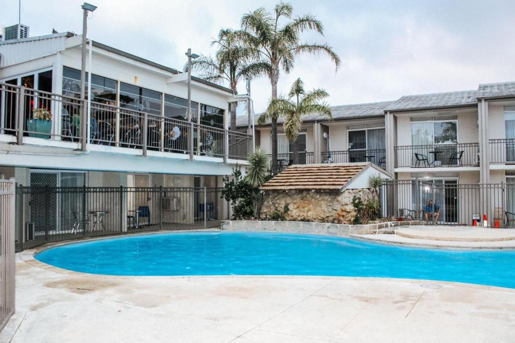 eine Villa mit einem Pool vor einem Gebäude in der Unterkunft Paradise Palms in Mandurah