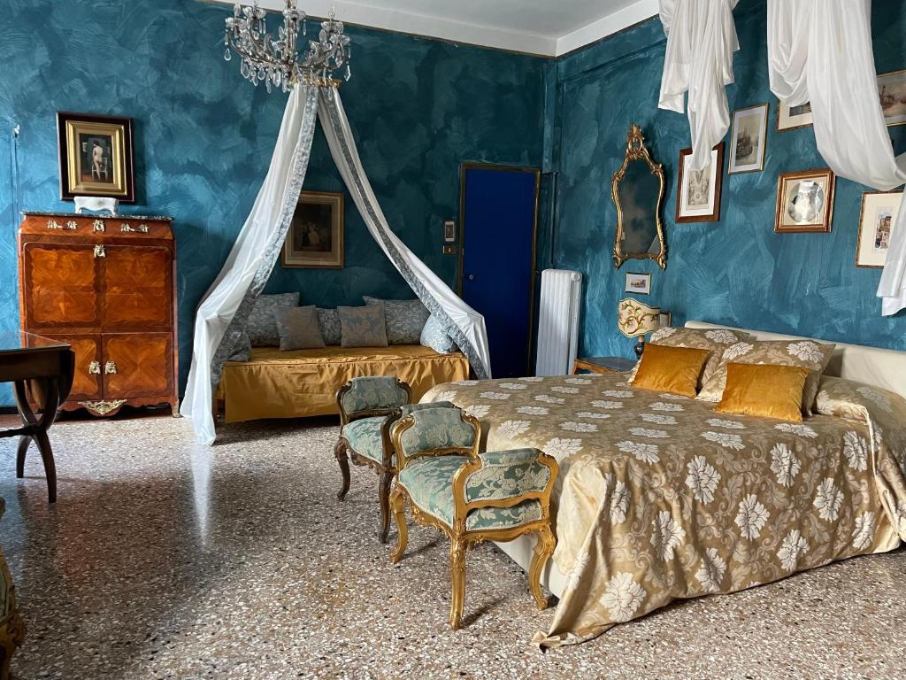 a bedroom with blue walls and a bed and chairs at Gabrielle's room in Venice