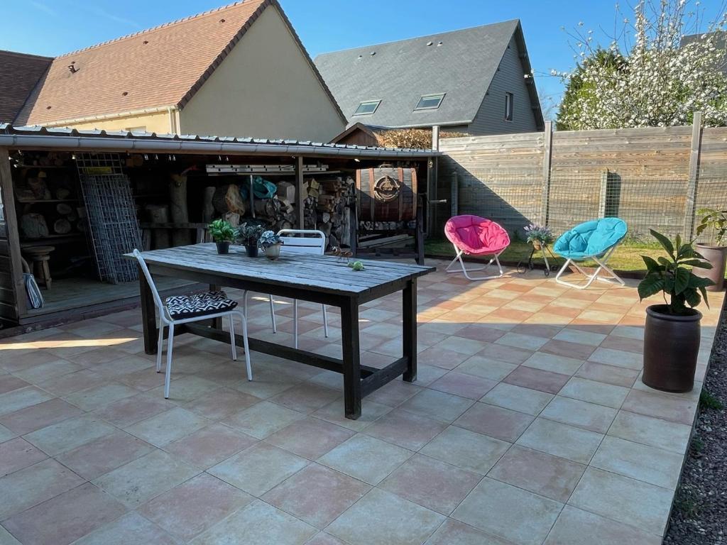 eine Terrasse mit einem Tisch und Stühlen auf einer Terrasse in der Unterkunft Gîte Pressoir Armand in Saint-Gatien-des-Bois