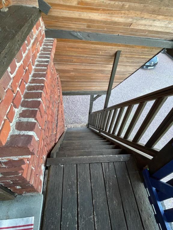 a staircase with a brick wall next to a stair case at Gîte Pressoir Armand in Saint Gatien des Bois