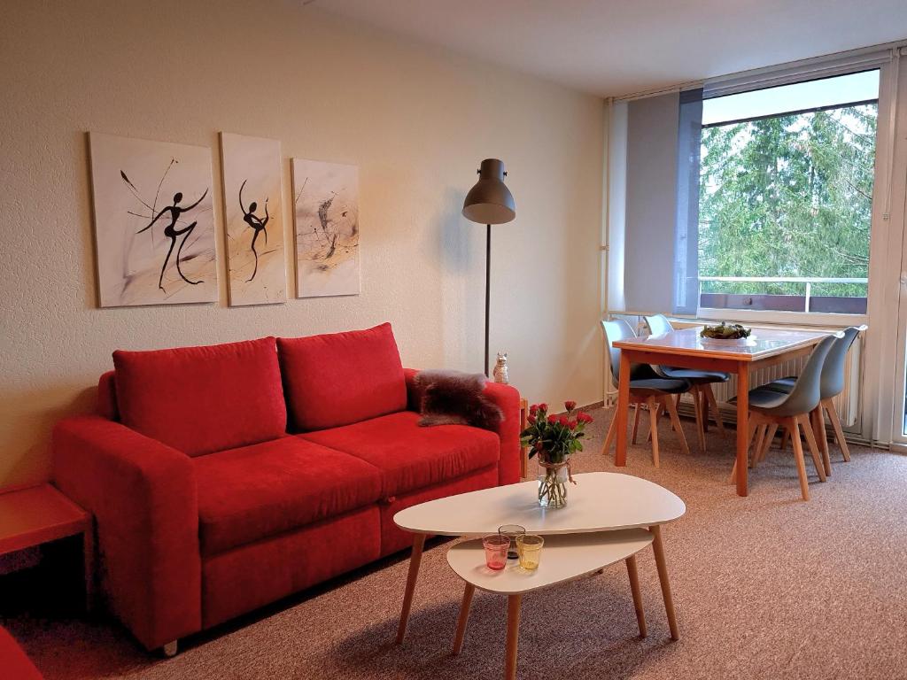 sala de estar con sofá rojo y mesa en Hike & Bike, en Altenau