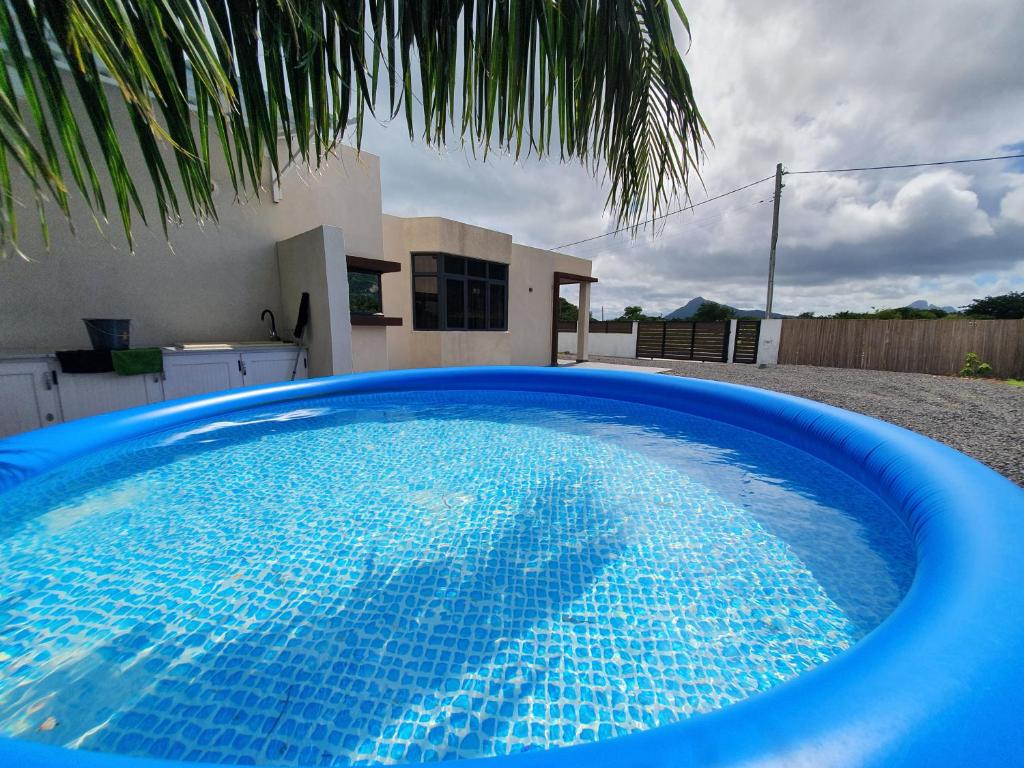uma grande piscina azul em frente a uma casa em Equinox Kite Villa em La Gaulette