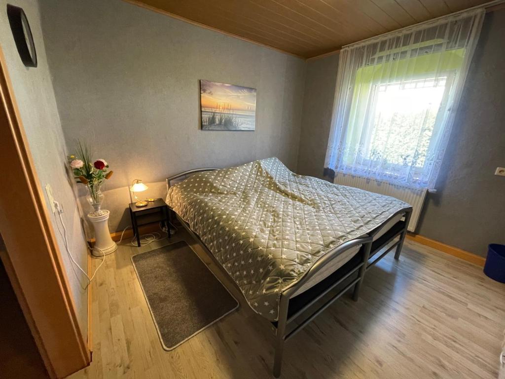Habitación pequeña con cama y ventana en Fremdenzimmer Nossen, en Nossen