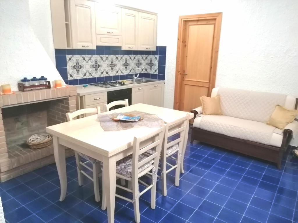 kuchnia ze stołem, krzesłami i kanapą w obiekcie Villetta La Bluette Capo Vaticano w mieście Capo Vaticano