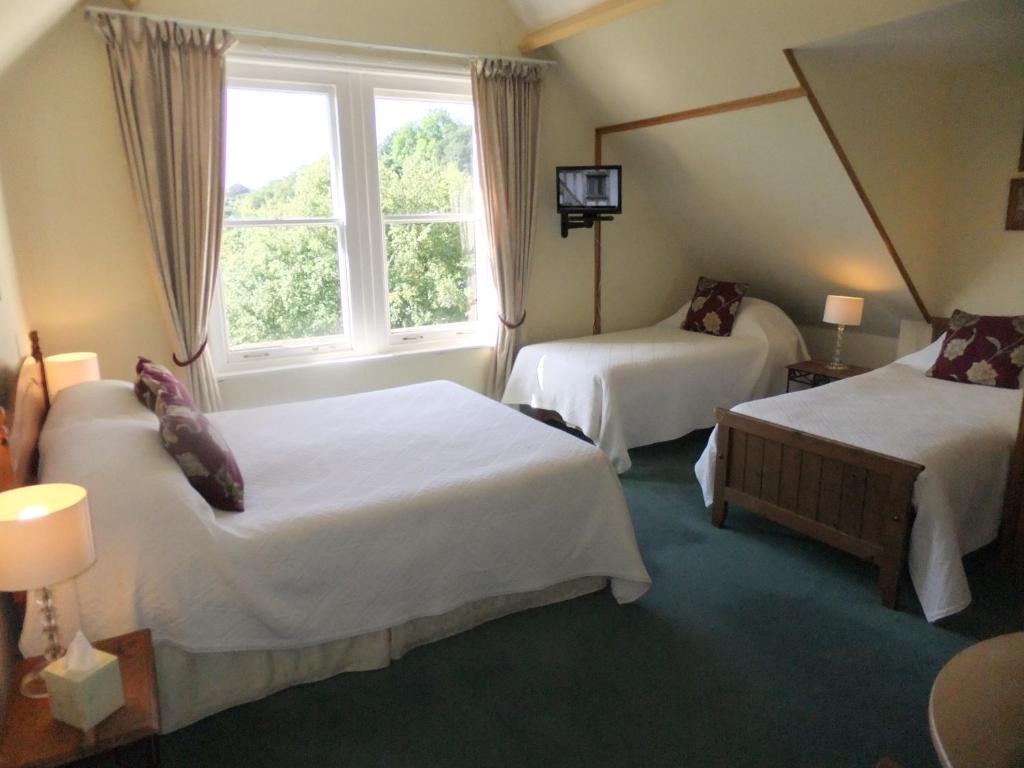 a hotel room with two beds and a window at Elgin Villa in Bath