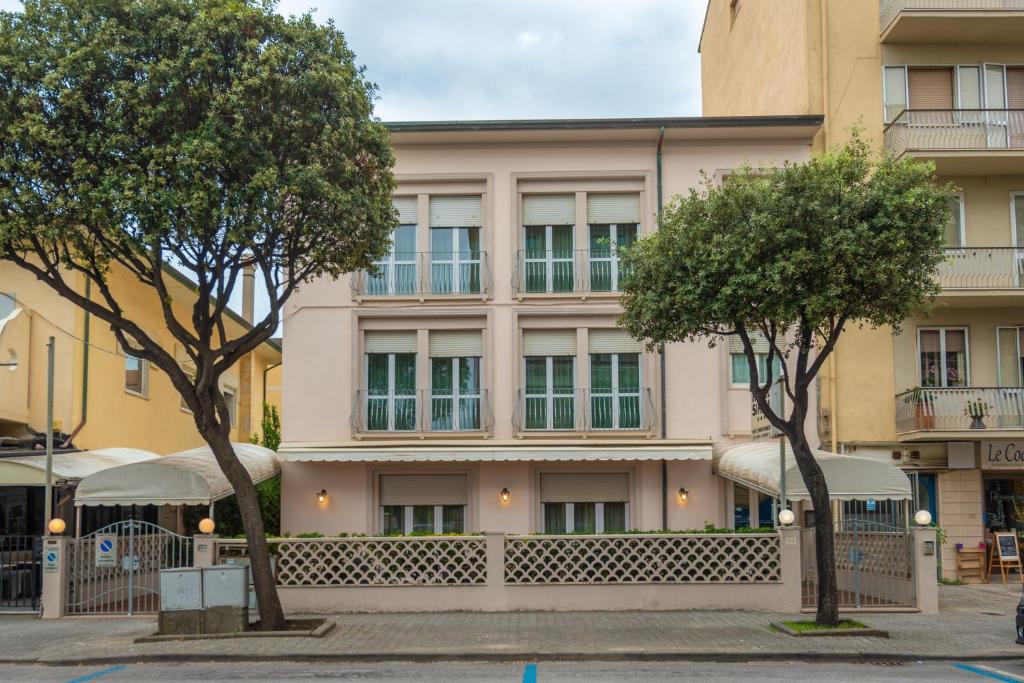 a building with trees in front of it at Hotel Sirena in Lido di Camaiore