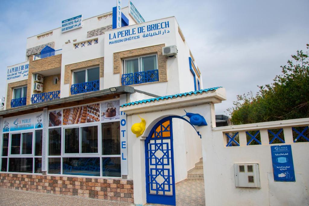 budynek z niebiesko-białą fasadą w obiekcie La Perle De Briech w mieście Asila