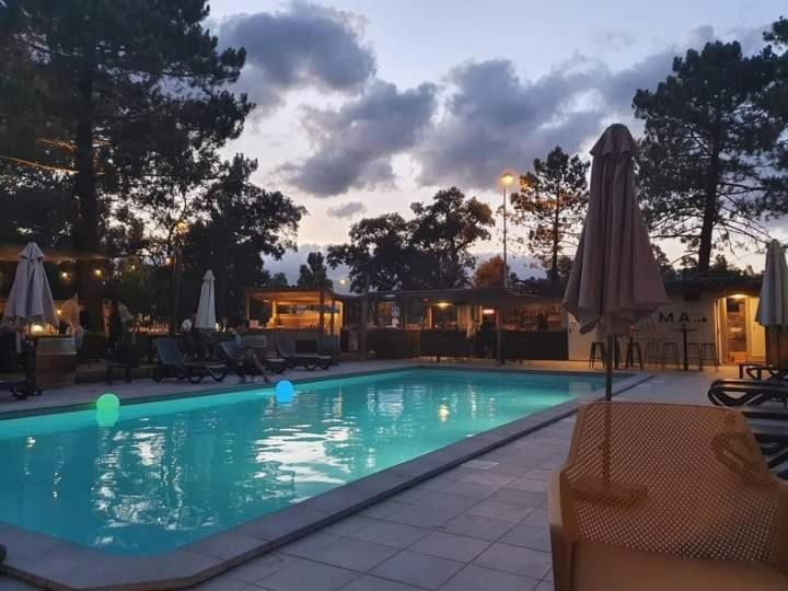 a swimming pool with a sunset in the background at Camping U STABIACCIU in Porto-Vecchio