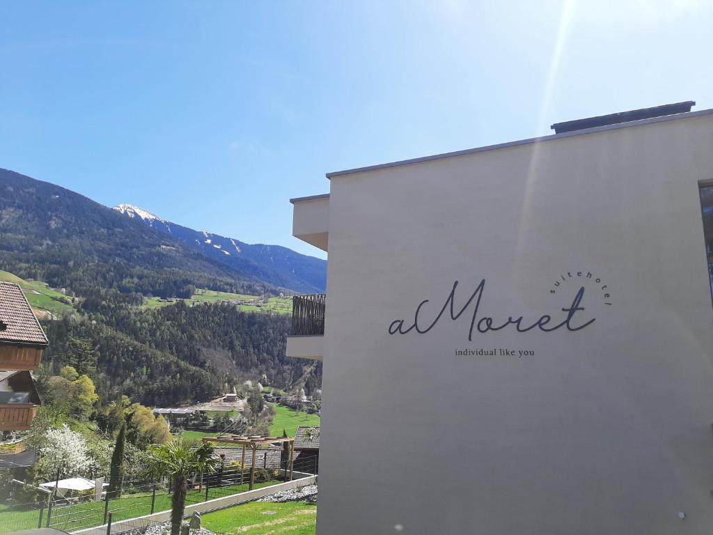 a sign on the side of a building with a mountain at Residence aMoret in Bressanone