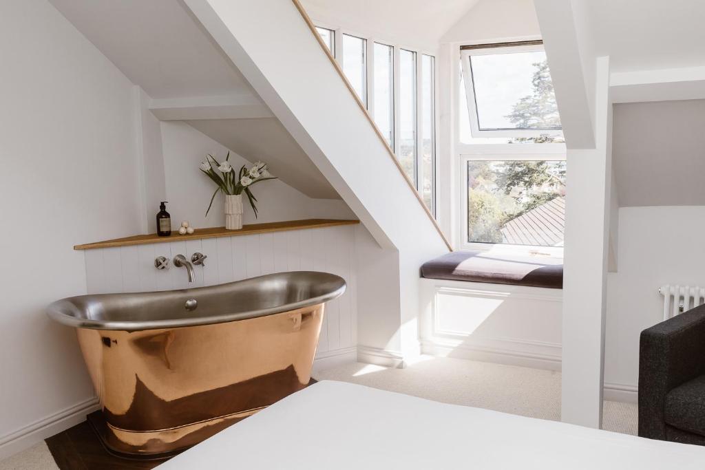 a bathroom with a copper tub in a stair case at The Sandy Duck in Falmouth