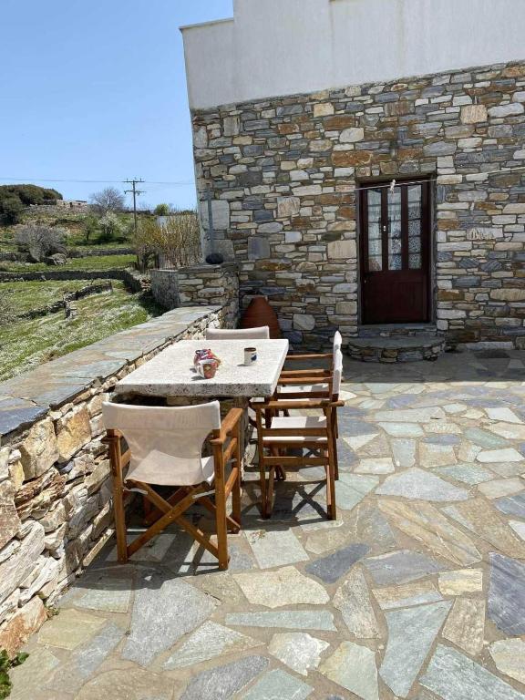 a table and chairs on a stone patio at Fabrica apartments in Apeiranthos