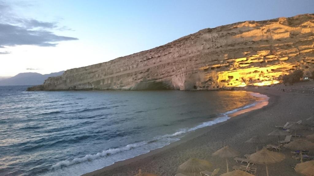 een strand met parasols en de oceaan bij Marilena in Matala