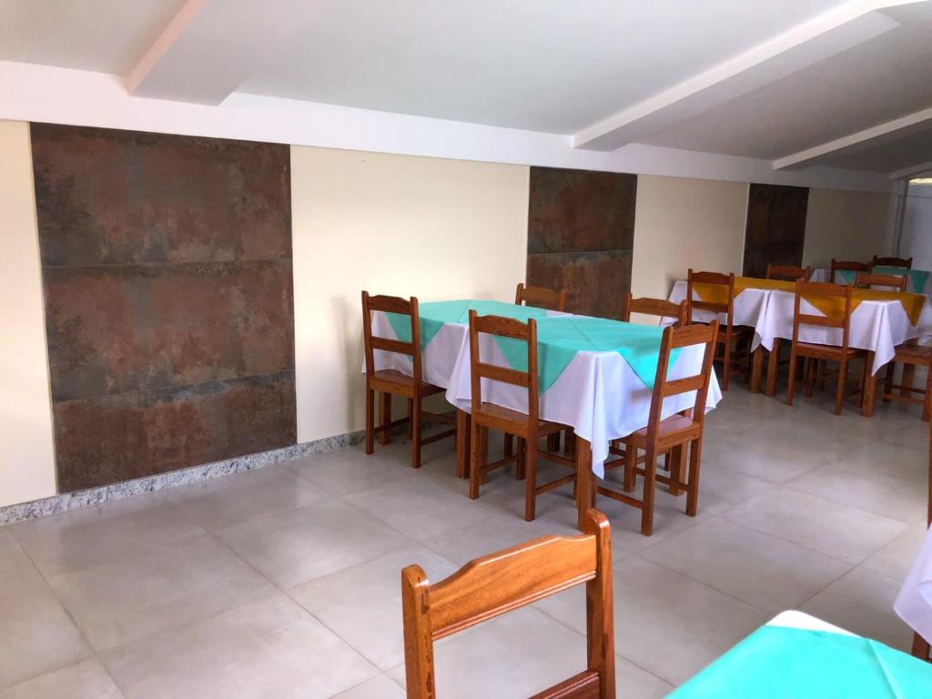 a dining room with a blue table and chairs at Minas Hotel Unidade Centro in Mariana