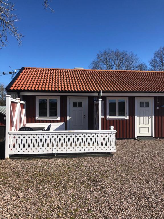 una pequeña casa con una cerca blanca delante de ella en Skattegårdens Gästhus en Falköping