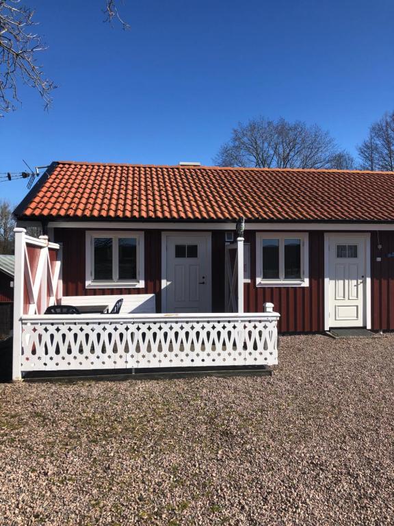 una pequeña casa con una cerca blanca delante de ella en Skattegårdens Gästhus, en Falkoping