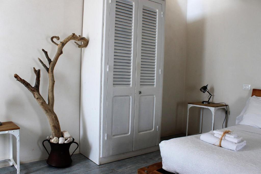 a bedroom with a white door and a tree at Dei Serafini in Polignano a Mare