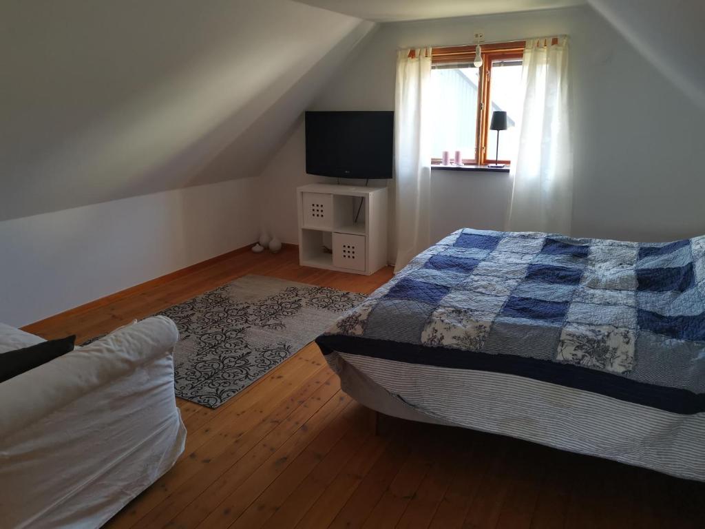 1 dormitorio con 1 cama y TV en Gotland, Hästgård i Stånga, en Stånga