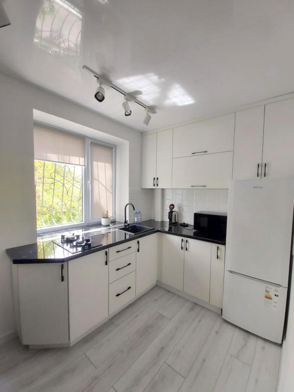 a kitchen with white cabinets and a white refrigerator at 2-х комнатная квартира in Taraz
