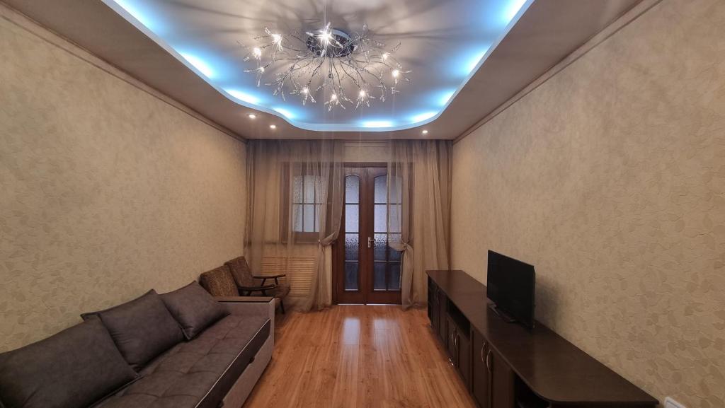 a living room with a couch and a ceiling at Cosy appartment in Tashkent