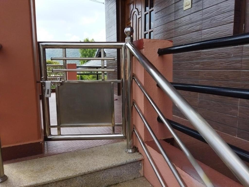 an open door of a building with a metal railing at Hidden gem home stay in Madikeri