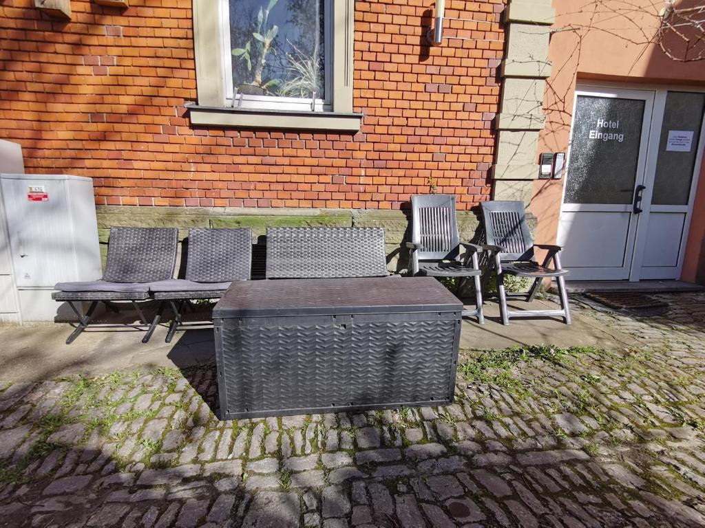 einer Gruppe von Stühlen und einem Tisch vor einem Gebäude in der Unterkunft Hotel Kitzinger Hof an der B8 in Kitzingen