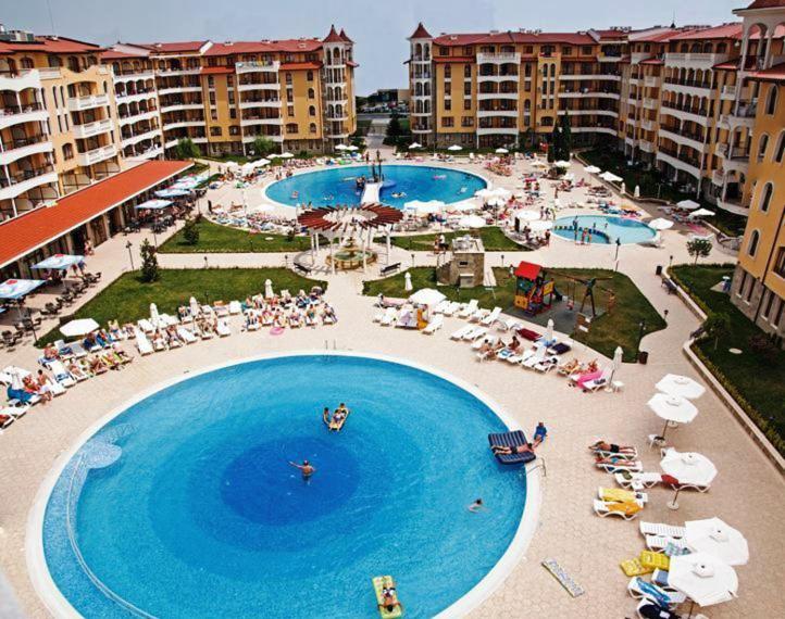 an overhead view of a large pool with people sitting around it at Royal Sun Holiday Apartments in Sunny Beach