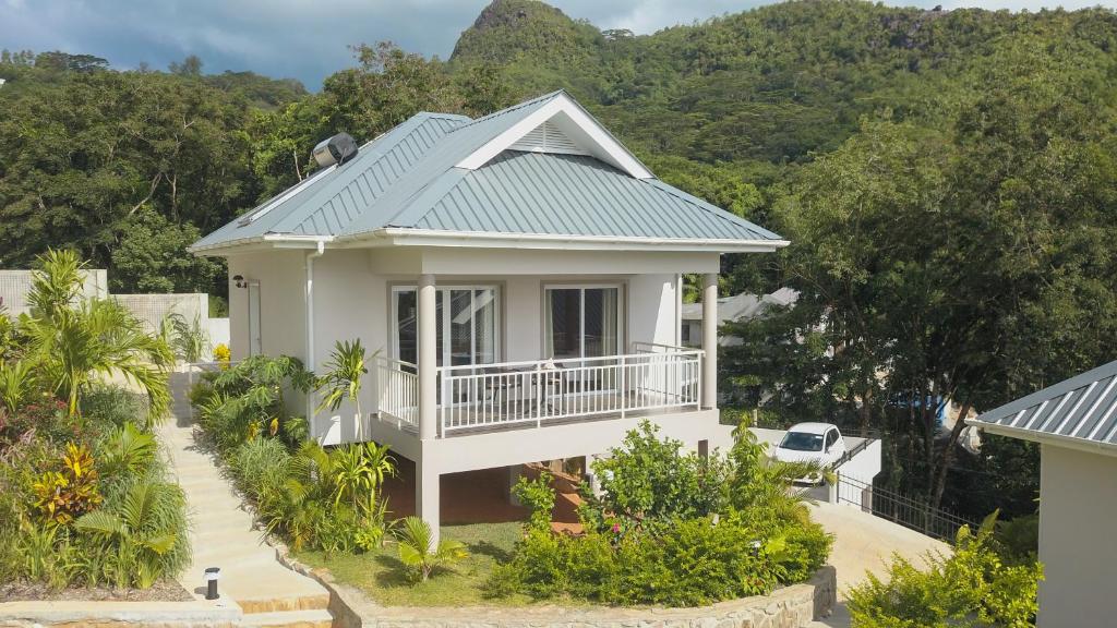 ein weißes Haus mit grünem Dach in der Unterkunft La Trouvaille in Anse a La Mouche