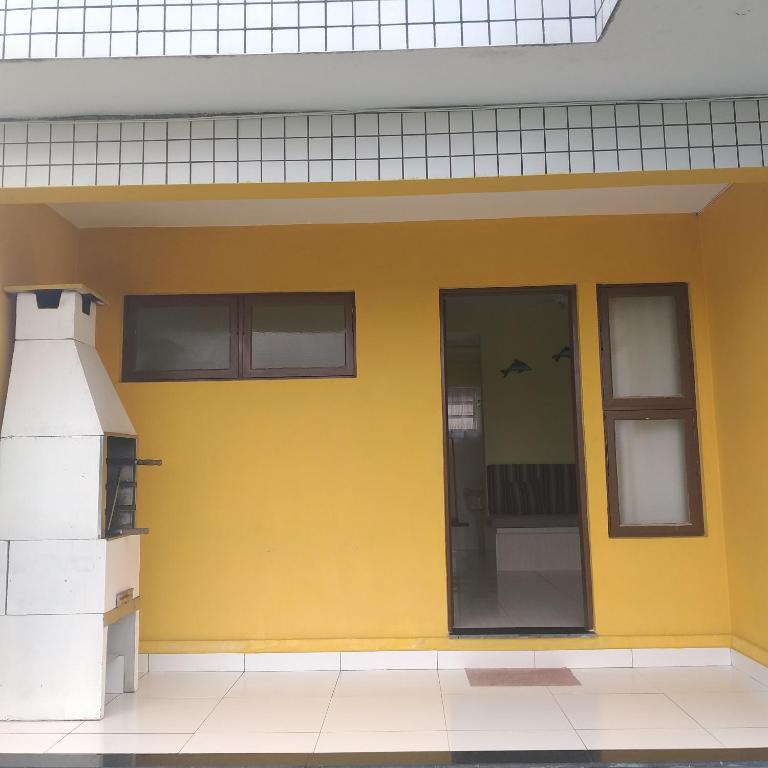 a yellow wall of a building with a window at Jane Ilha in Ilha Comprida