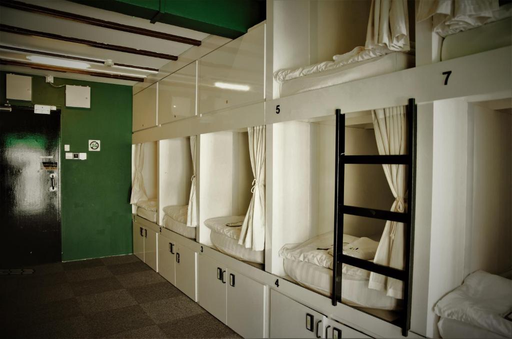 a row of bunk beds in a room at Wink at Mosque Street in Singapore