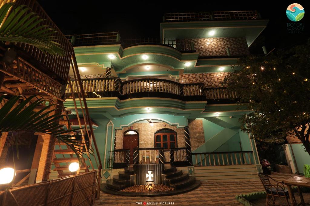 una casa di notte con una scala davanti di Tropical Wave Hostel Morjim a Morjim
