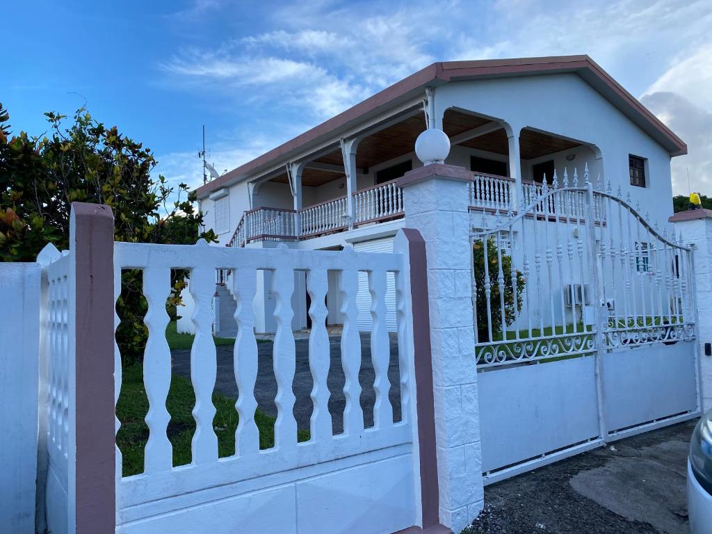 a house with a white fence and a white gate at Villa Mer'Pelée in Saint-Pierre